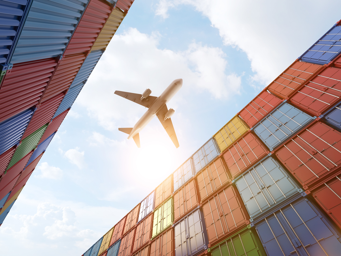Aerospace import duties depicted by plane flying above shipping containers